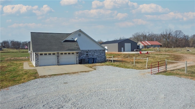 view of home's exterior featuring a garage, concrete driveway, fence, and a shingled roof