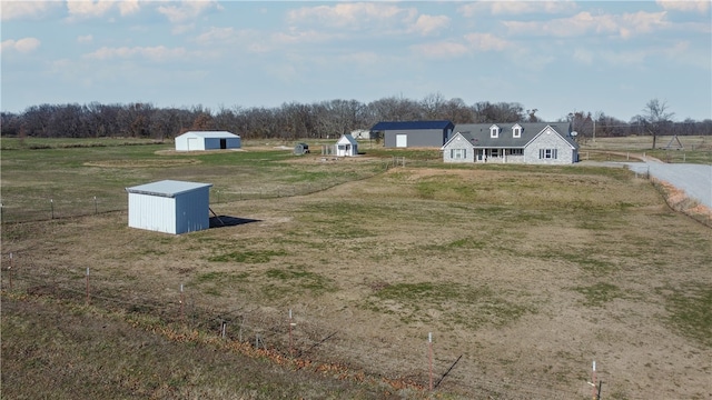 view of yard featuring a garage, an outbuilding, a rural view, and a storage unit