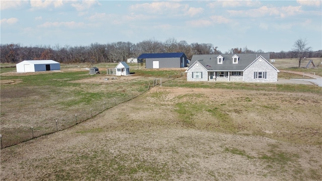 view of yard with a pole building, a detached garage, fence, and an outdoor structure