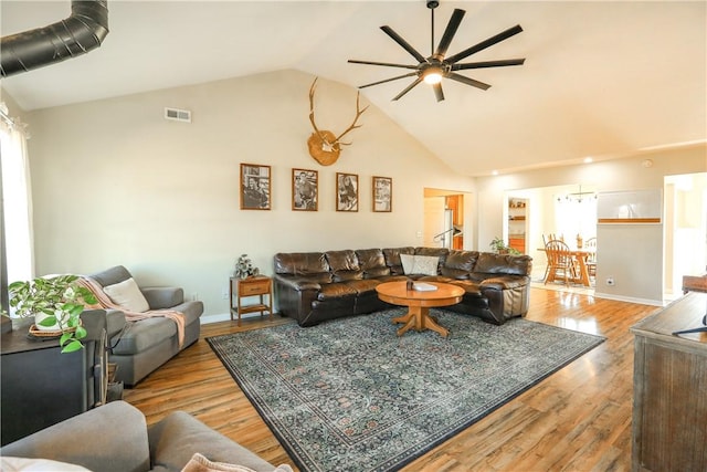 living room featuring ceiling fan, light hardwood / wood-style floors, and lofted ceiling