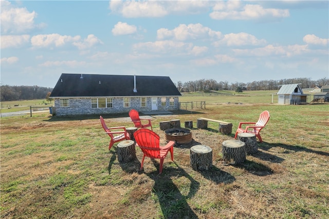 view of yard featuring an outbuilding, a rural view, and a fire pit