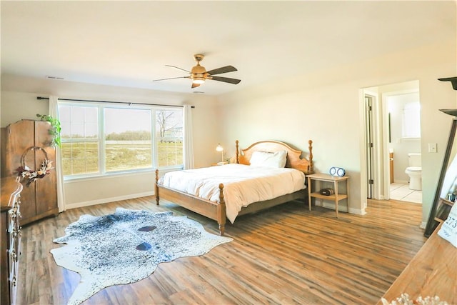 bedroom with ceiling fan, ensuite bathroom, and hardwood / wood-style flooring