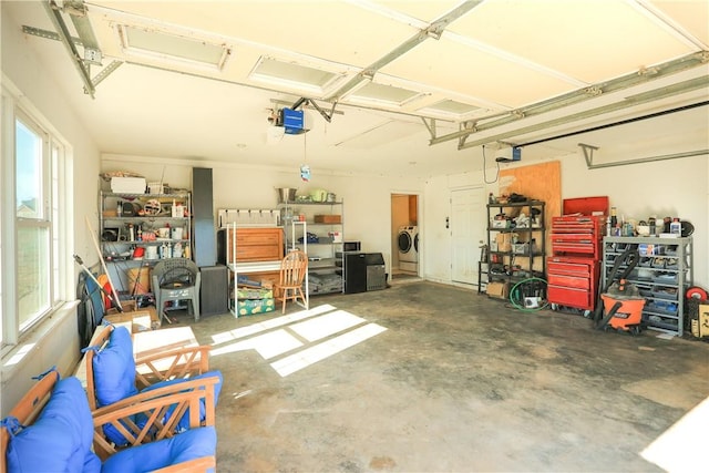 garage featuring washer and clothes dryer, a workshop area, and a garage door opener