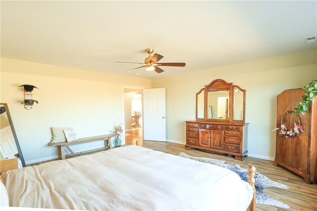 bedroom featuring a ceiling fan, baseboards, and wood finished floors