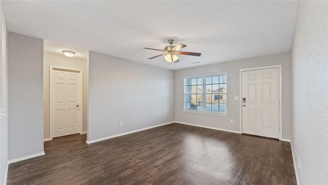 unfurnished room with ceiling fan and dark wood-type flooring