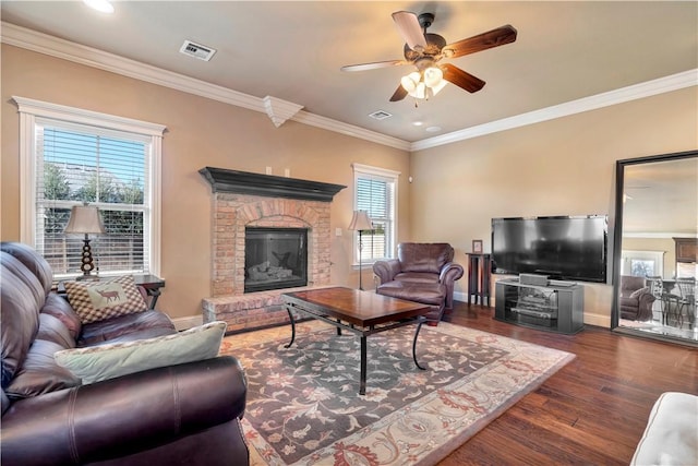 living room with dark hardwood / wood-style floors, crown molding, plenty of natural light, and a fireplace