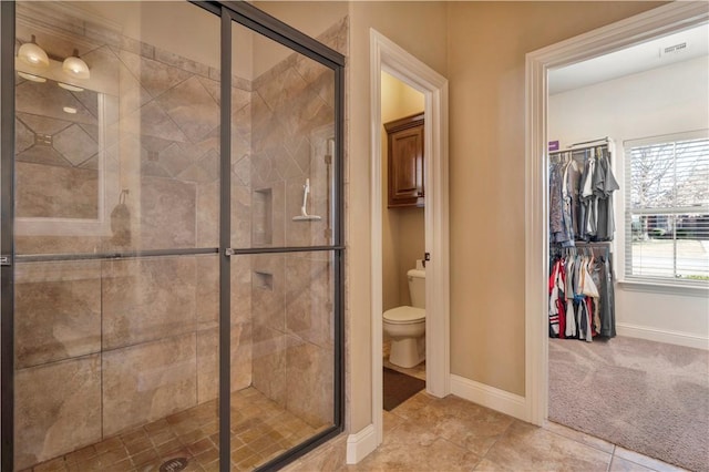 bathroom featuring tile patterned floors, toilet, and walk in shower