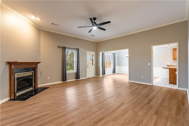 unfurnished living room featuring ornamental molding, ceiling fan, light hardwood / wood-style flooring, and a tile fireplace