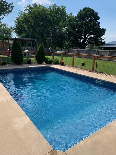 view of swimming pool featuring a lawn