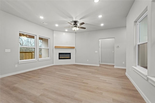 unfurnished living room with ceiling fan, light hardwood / wood-style floors, and a fireplace