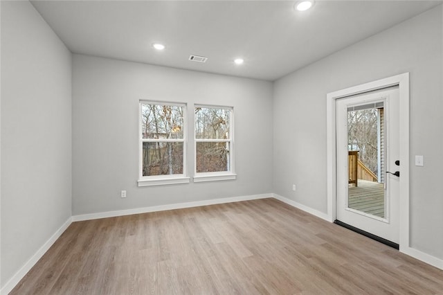 spare room with light hardwood / wood-style floors and plenty of natural light