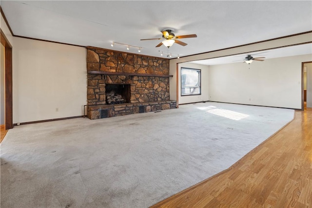 unfurnished living room featuring a stone fireplace, ceiling fan, and light wood-type flooring