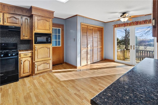 kitchen featuring french doors, light hardwood / wood-style floors, black appliances, exhaust hood, and ornamental molding