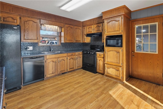 kitchen with sink, light hardwood / wood-style floors, and black appliances