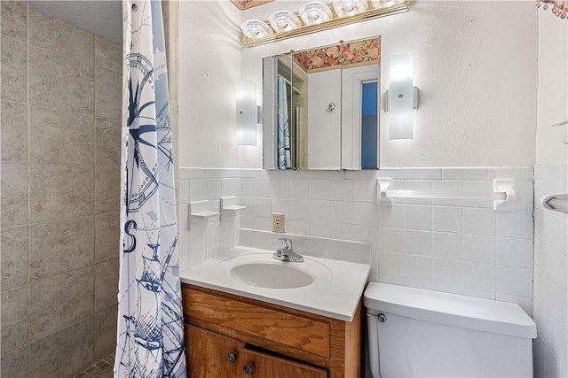 bathroom with a shower with curtain, vanity, tile walls, and toilet