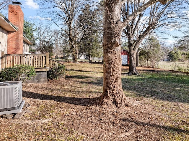 view of yard with central AC unit and a wooden deck