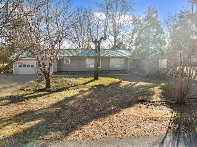 single story home featuring a garage and a front lawn