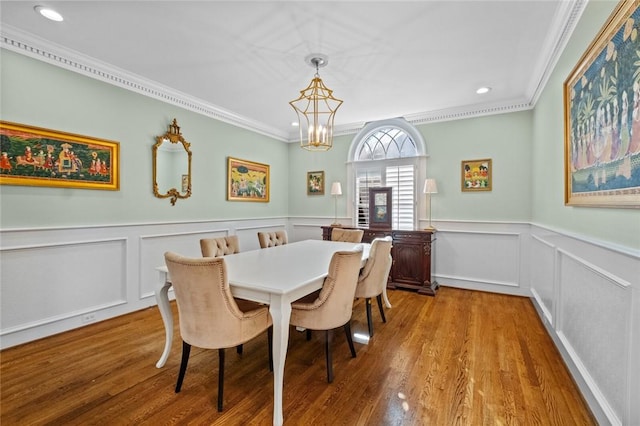 dining area featuring light wood-type flooring, an inviting chandelier, and ornamental molding