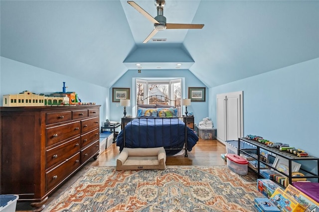 bedroom with light hardwood / wood-style flooring, vaulted ceiling, and ceiling fan