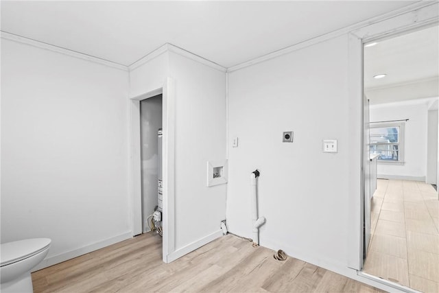 laundry area featuring hookup for an electric dryer, ornamental molding, and light hardwood / wood-style flooring