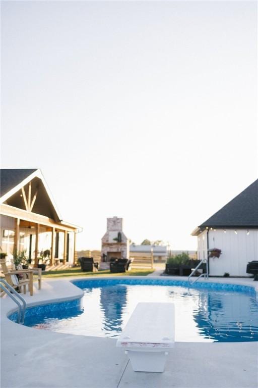 view of swimming pool with a patio and a fireplace