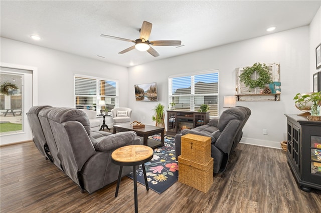 living room with ceiling fan and dark wood-type flooring