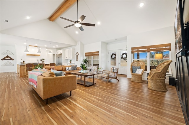 living room with french doors, ceiling fan, light wood-type flooring, high vaulted ceiling, and beam ceiling