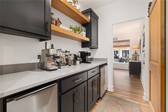 bar featuring light hardwood / wood-style floors, stainless steel dishwasher, a barn door, and wine cooler