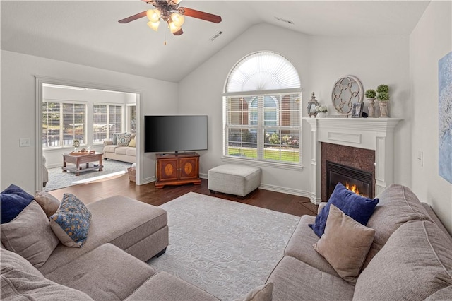 living room featuring lofted ceiling, a high end fireplace, a healthy amount of sunlight, and dark hardwood / wood-style floors