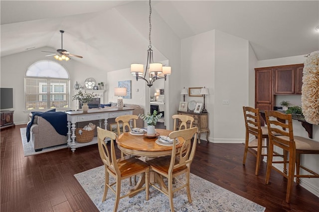 dining space with lofted ceiling, dark hardwood / wood-style flooring, and ceiling fan with notable chandelier