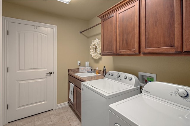 laundry area with washing machine and dryer, sink, light tile patterned flooring, and cabinets