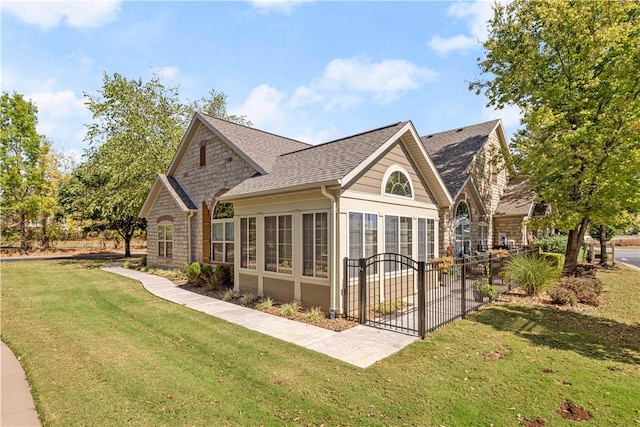 back of property featuring a sunroom and a lawn