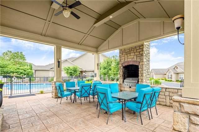 view of patio featuring an outdoor stone fireplace, a grill, ceiling fan, and a community pool