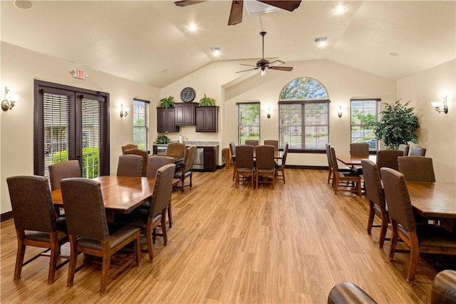 dining area with ceiling fan, vaulted ceiling, and light wood-type flooring