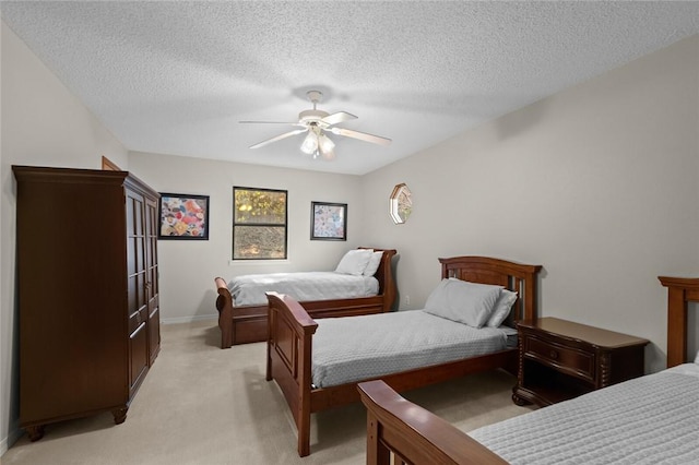 carpeted bedroom with ceiling fan and a textured ceiling