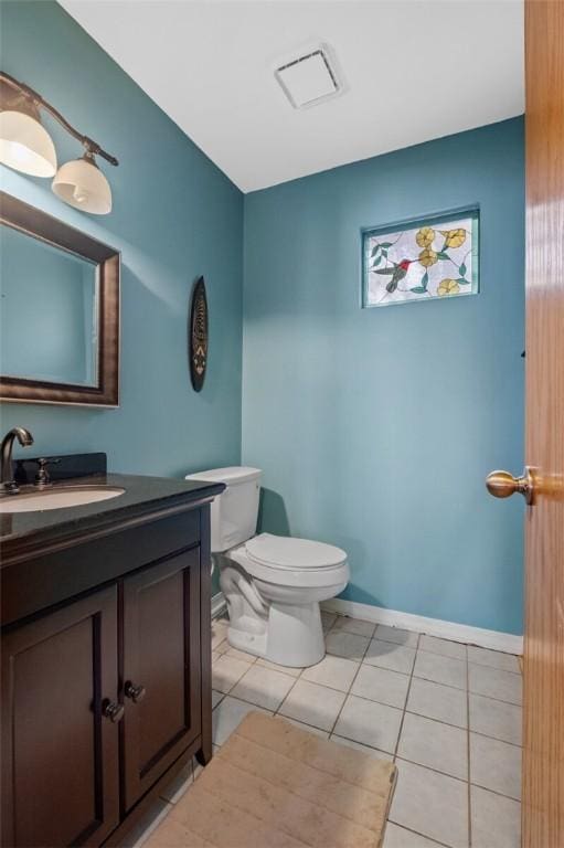 bathroom with tile patterned flooring, vanity, and toilet