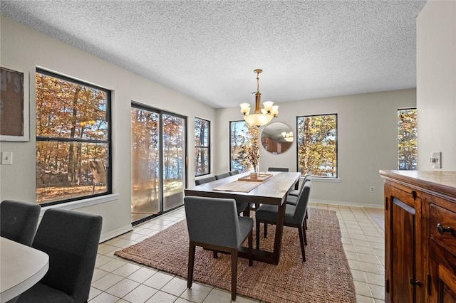 tiled dining space featuring a textured ceiling and an inviting chandelier