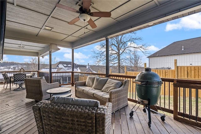 wooden deck with outdoor lounge area and ceiling fan