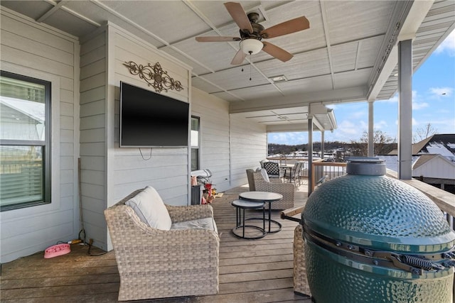 wooden terrace with ceiling fan and a grill