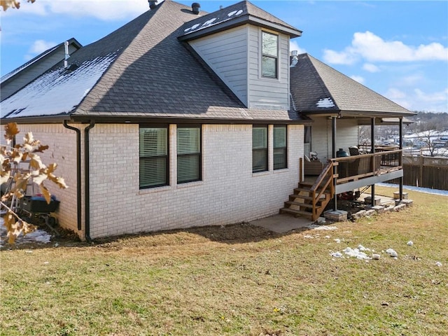 back of house featuring a lawn and a deck