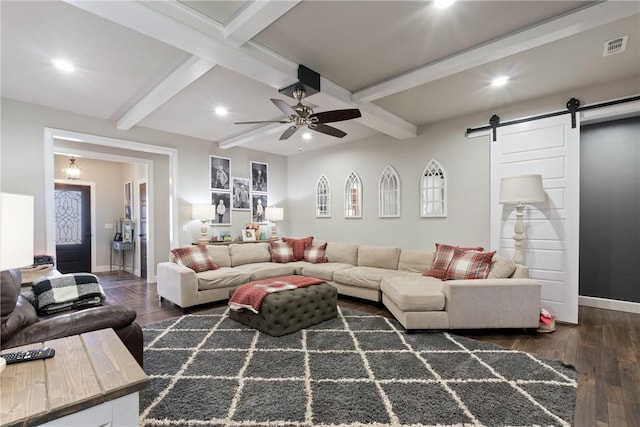 living room featuring a barn door, ceiling fan, beamed ceiling, and dark wood-type flooring