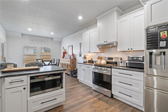 kitchen with decorative backsplash, appliances with stainless steel finishes, dark hardwood / wood-style floors, and white cabinetry