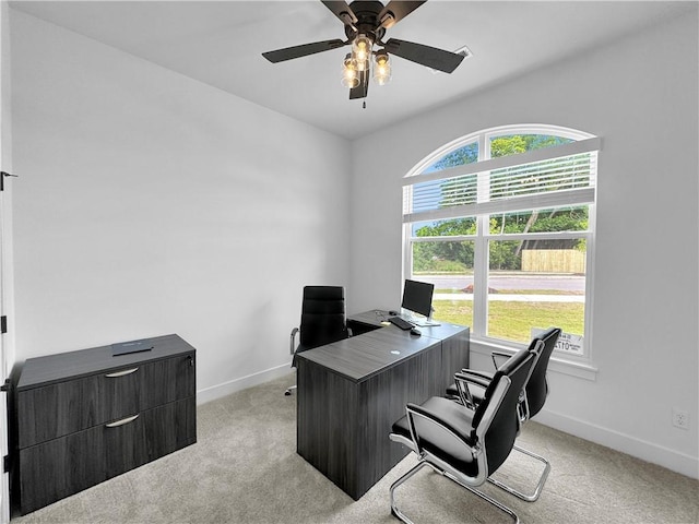 office featuring baseboards, light colored carpet, and a healthy amount of sunlight