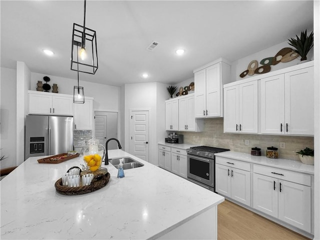 kitchen featuring visible vents, pendant lighting, a sink, white cabinetry, and appliances with stainless steel finishes