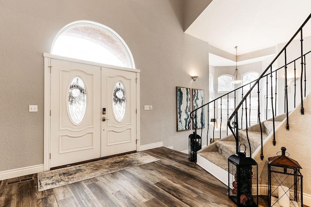 foyer entrance with hardwood / wood-style flooring and a notable chandelier