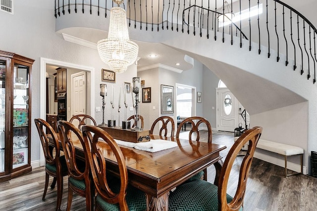 dining area with a chandelier, dark hardwood / wood-style floors, and ornamental molding