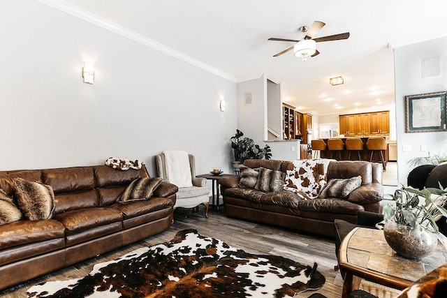 living room featuring ceiling fan, wood-type flooring, and crown molding