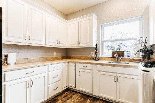 kitchen featuring white cabinets, white range oven, dark hardwood / wood-style flooring, and sink