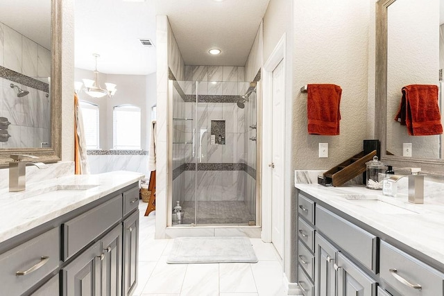 bathroom with vanity, an inviting chandelier, and walk in shower