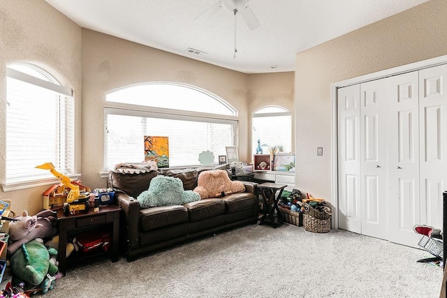 living room with ceiling fan, carpet floors, and a wealth of natural light